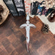 Nevernight Metal Dagger Replica displayed in front of some book edges and a pinecone.